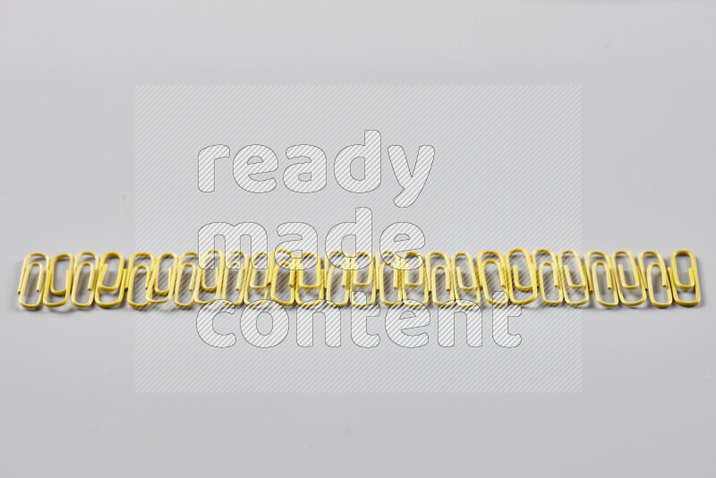 Yellow paper clips isolated on a grey background