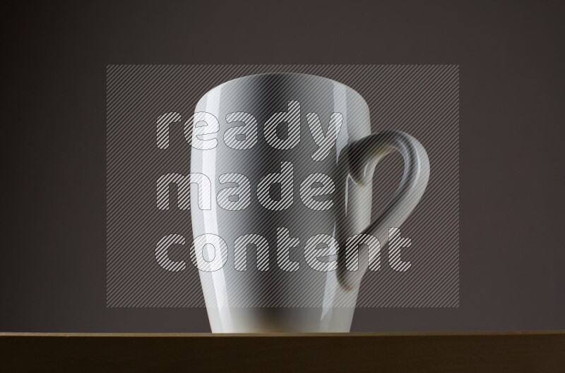 Low angle shot of a white cup on grey background