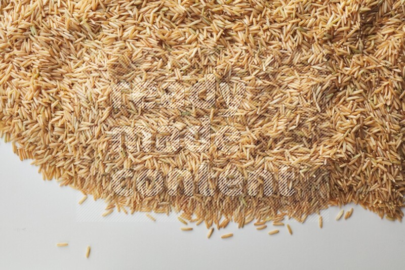 Top-view shot of long grain brown rice on white background