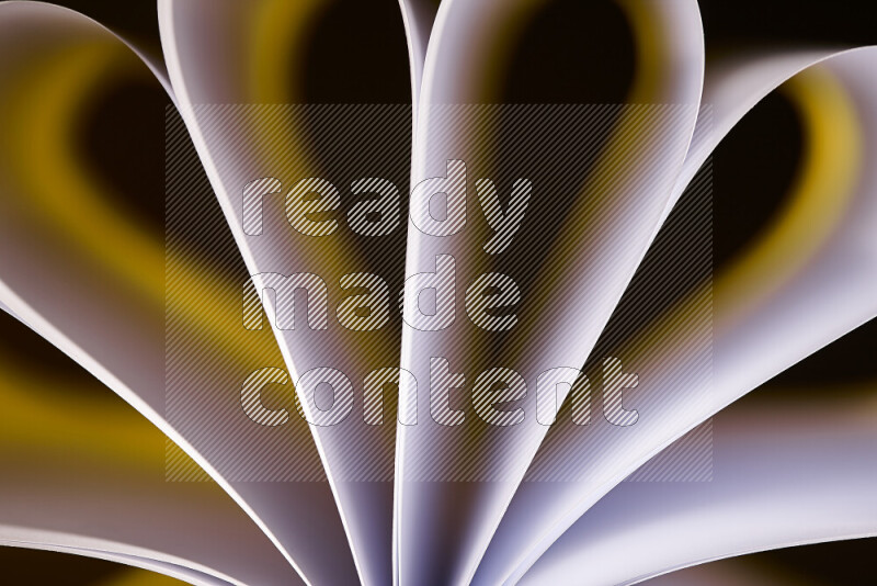 An abstract art piece displaying smooth curves in white and yellow gradients created by colored light