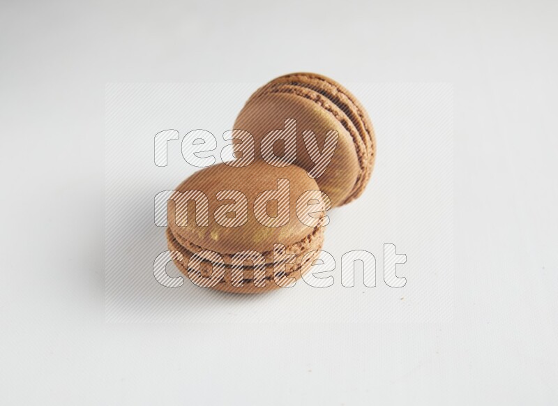 45º Shot of two Brown Coffee macarons on white background