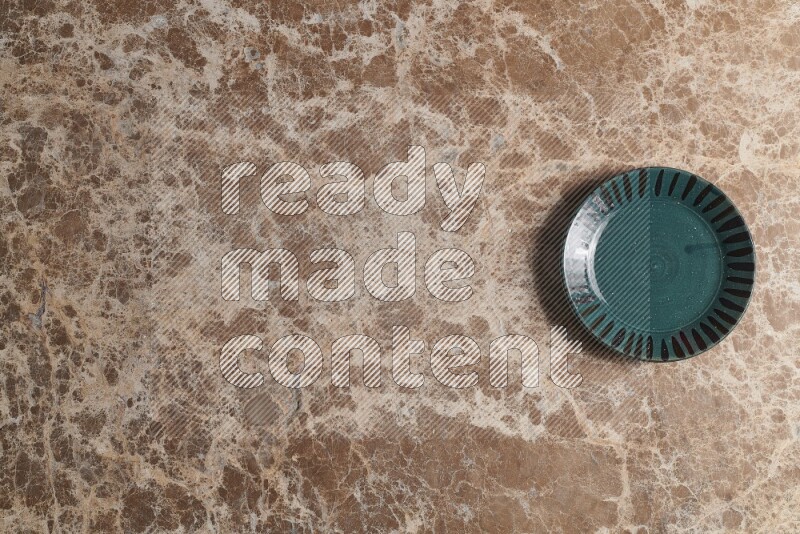 A multicolored pottery plate on beige marble background