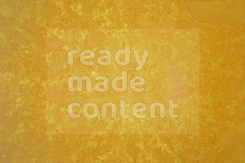 The image captures a dramatic splatter of yellow paint over a white backdrop