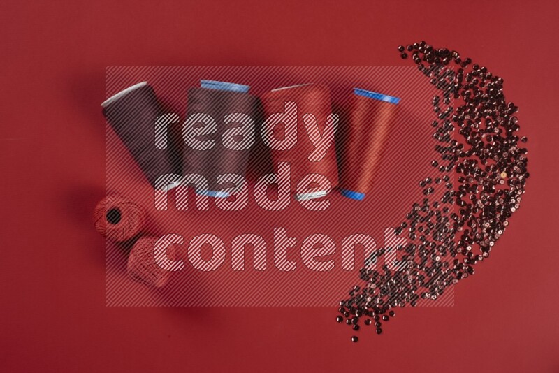 مجموعة من أدوات الخياطة والتفصيل حمراء اللون على خلفية حمراء