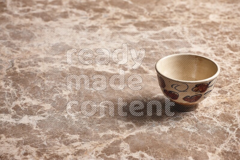 A decorative pottery bowl on beige marble background
