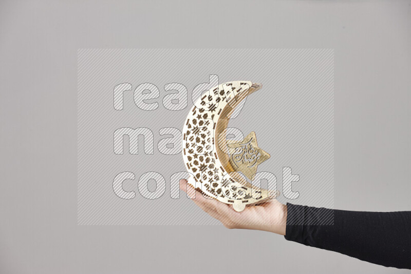 A woman in black abaya holding different ramadan lanterns in different positions