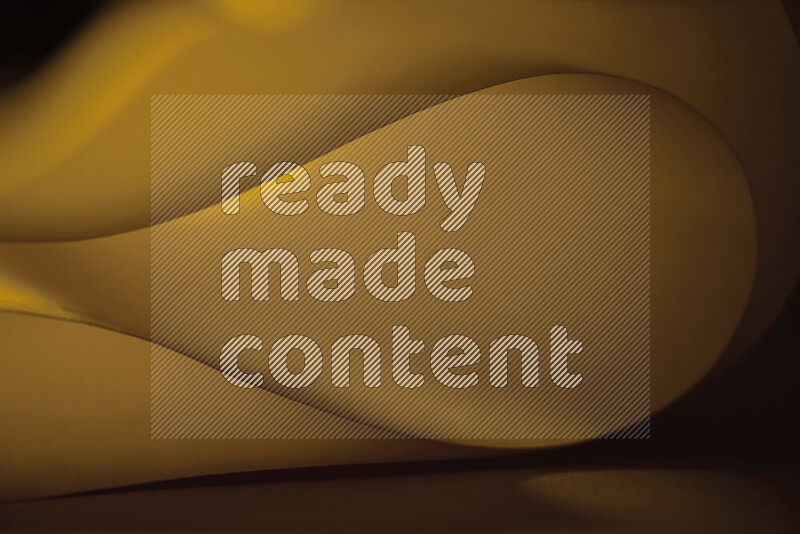 An abstract art piece displaying smooth curves in yellow gradients created by colored light