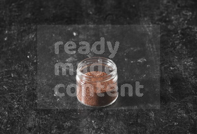 وعاء زجاجي ممتلئ ببذور حب الرشاد على أرضية سوداء