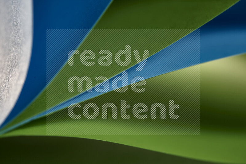 An abstract art showing blue and green paper sheets arranged in an overlapping curves
