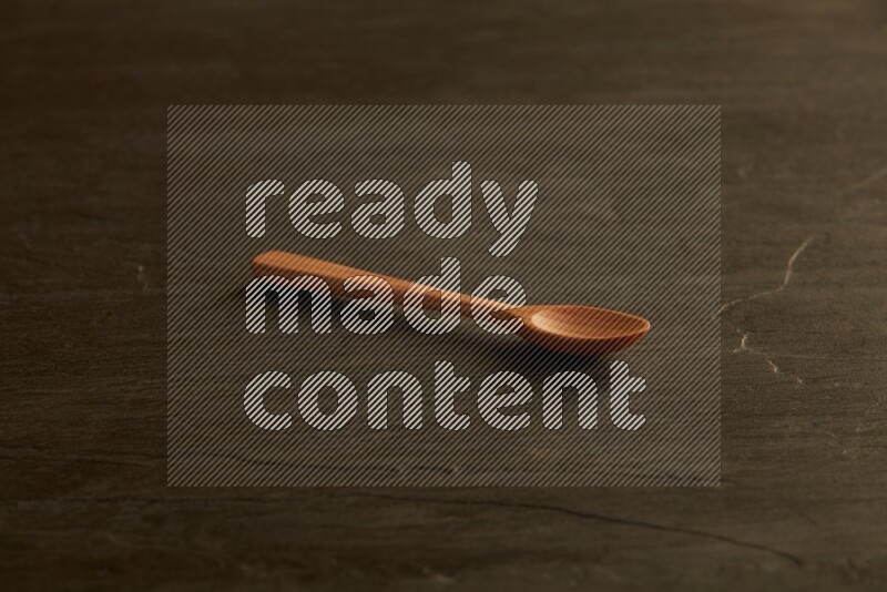 wooden spoon on black slate background