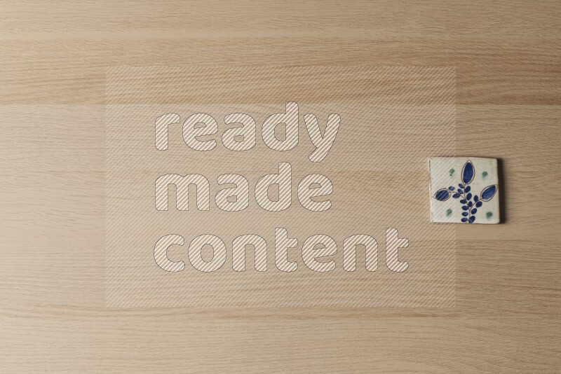 A decorative pottery coaster on light wooden background