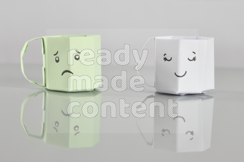 Origami cup on grey background