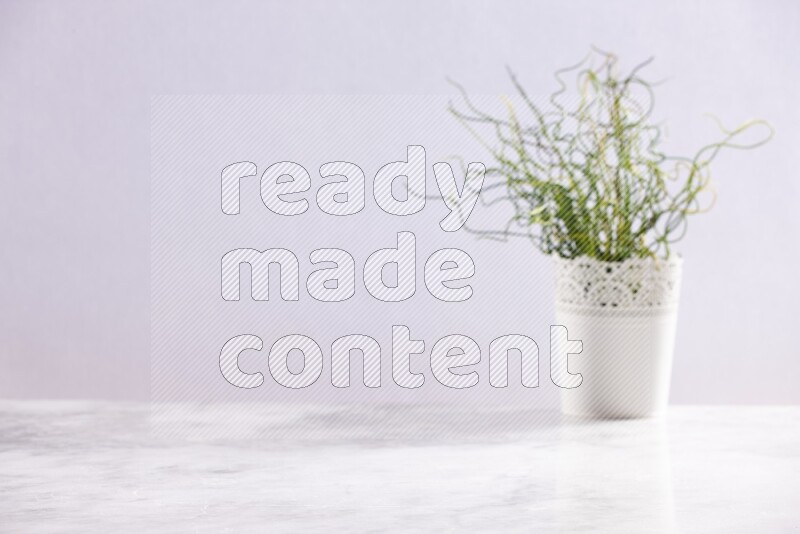 Artificial plant in white decorative pot on grey marble background