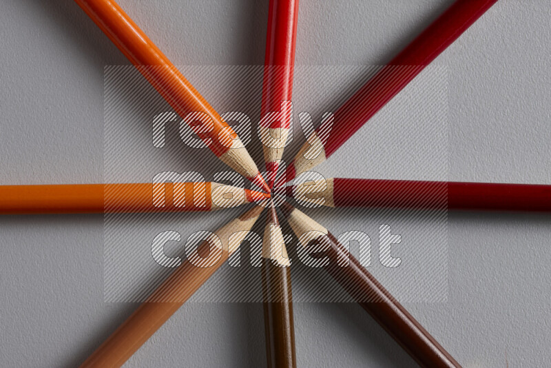 An arrangement of colored pencils in different colors on grey background