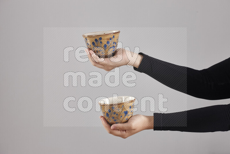 A woman in black abaya holding different pottery essentials in different positions