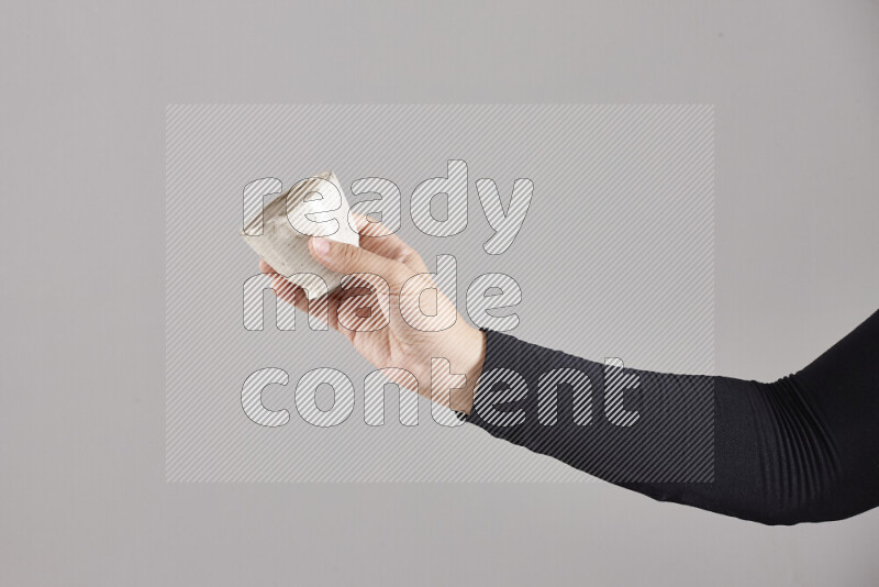 امرأة ترتدي عباءة سوداء تحمل أدوات فخارية مختلفة في أوضاع متعددة