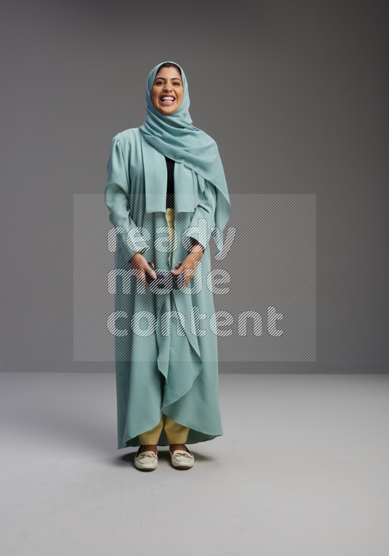 Saudi Woman wearing Abaya standing Playing Games on Gray background