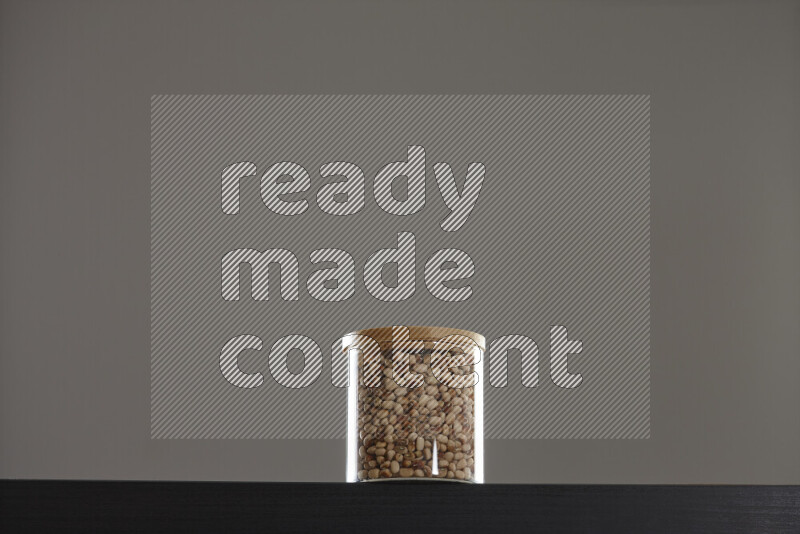Black-eyed peas in a glass jar on black background
