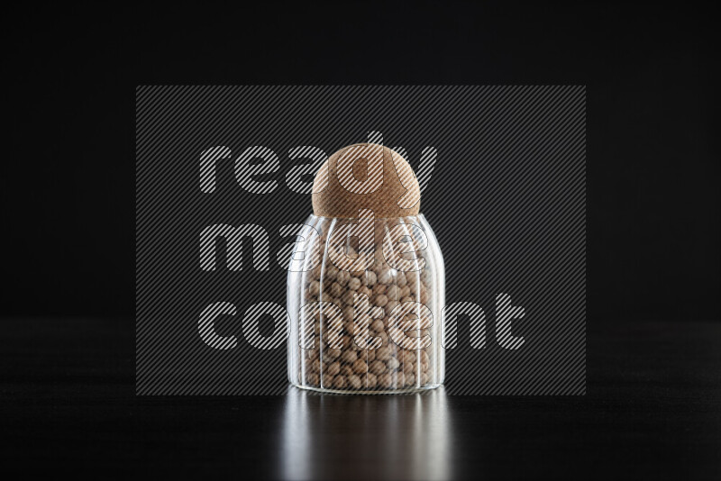 Chickpeas in a glass jar on black background