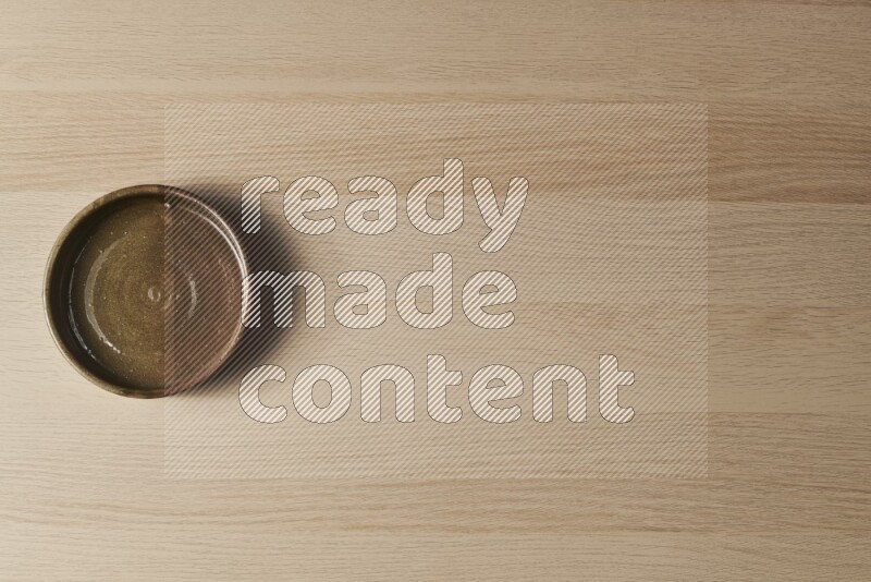 A multicolored pottery oven plate on light wooden background