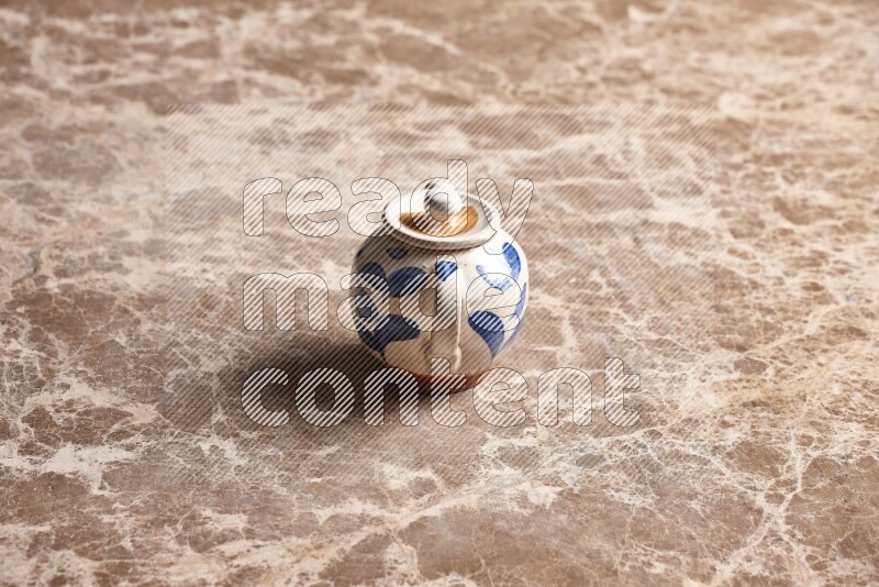 A pottery teapot on beige marble background