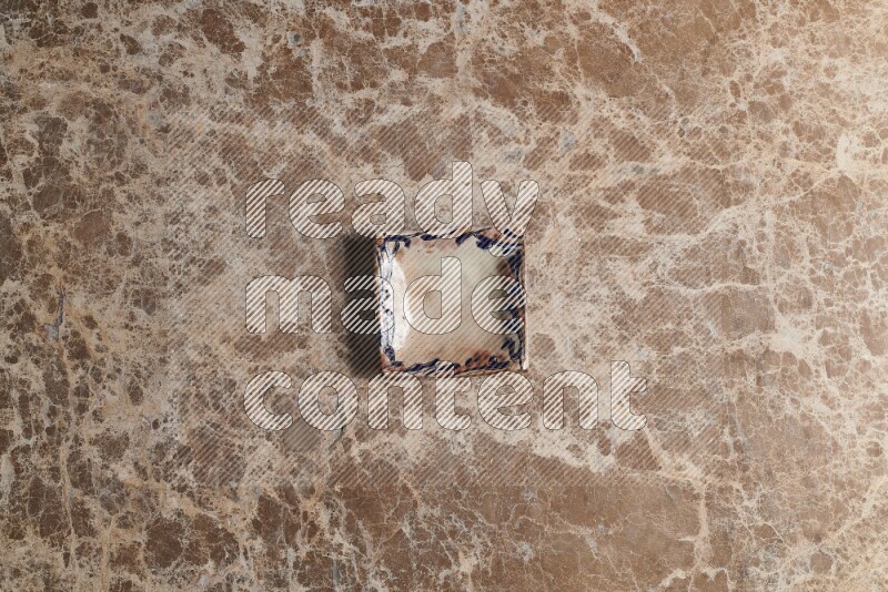 A decorative pottery plate on beige marble background
