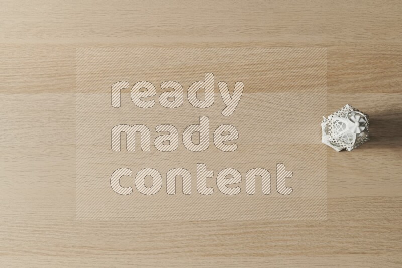 A candle lantern on light wooden background
