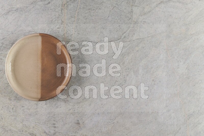 وعاء فرن فخاري متعدد الألوان على خلفية من الرخام الرمادي