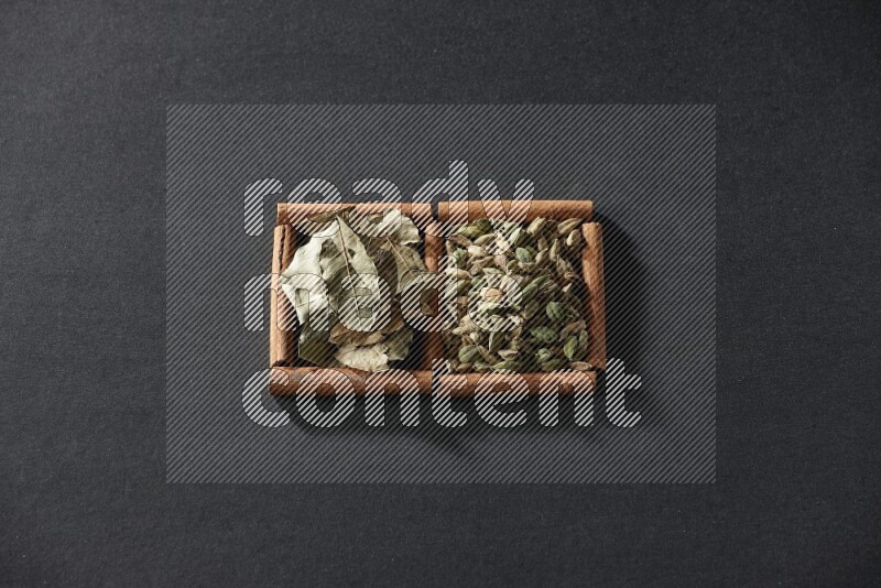 2 squares of cinnamon sticks full of cardamom and bay laurel leaves on black flooring