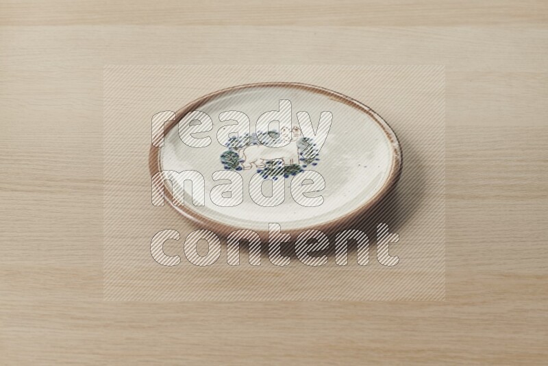 A decorative pottery plate on light wooden background