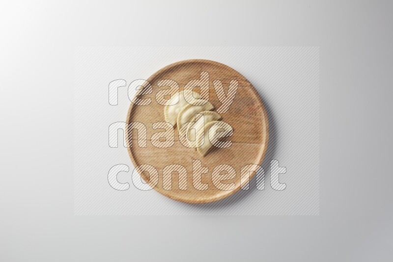 Four Sambosas on a wooden round plate on a white background