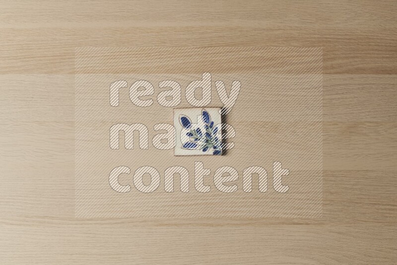 A decorative pottery coaster on light wooden background