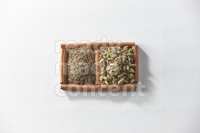 2 squares of cinnamon sticks full of cardamom and cumin on white flooring