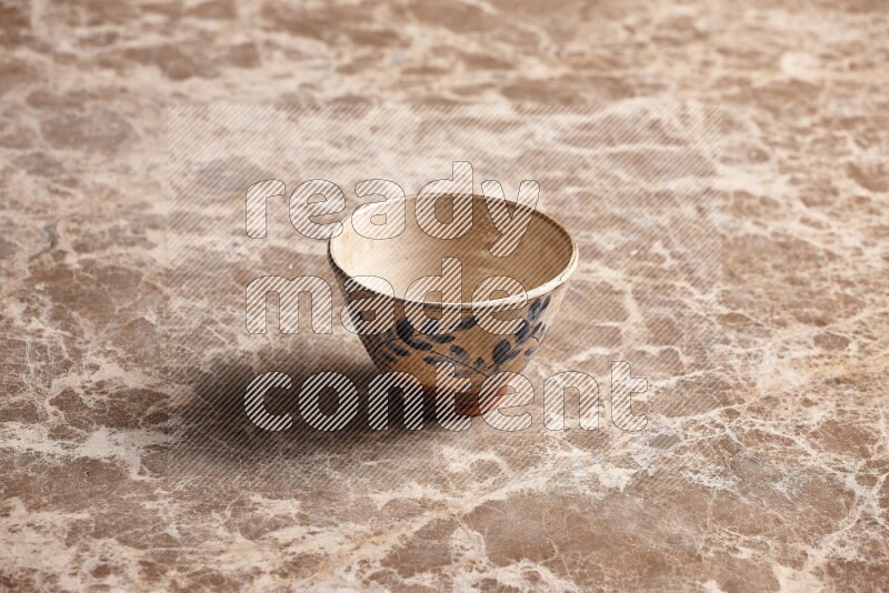 A decorative pottery bowl on beige marble background