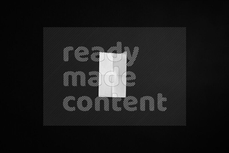 Folded notebook sheet on black background