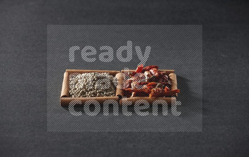 2 squares of cinnamon sticks full of chilis and white peppers on black flooring