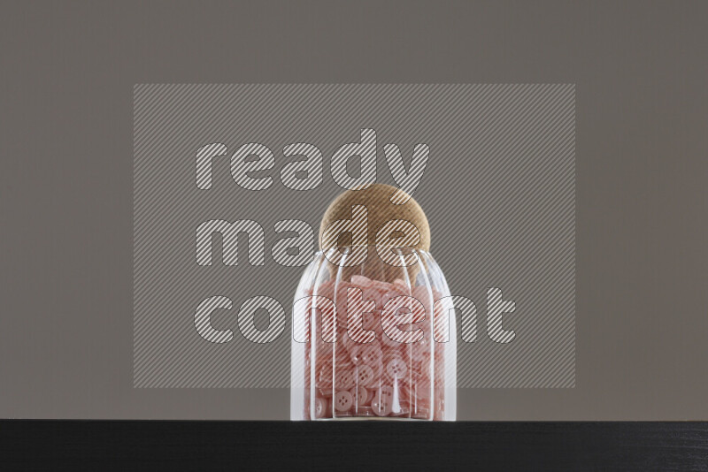 أزرار متنوعة في وعاء زجاجي علي خلفية سوداء