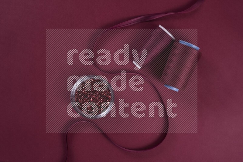 A red collection of sewing and tailoring tools arranged on a red background