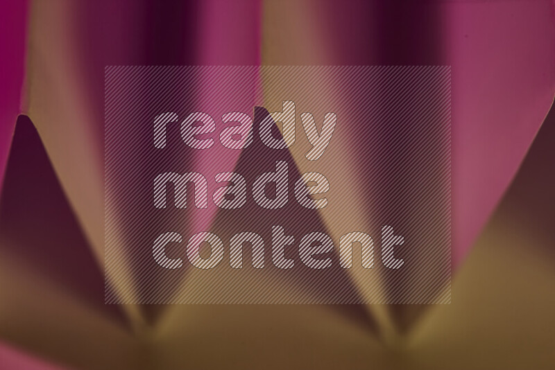 صورة مجردة مقربة تظهر طيات ورقية هندسية حادة بتدرجات اللون الوردي مع درجات لونية دافئة