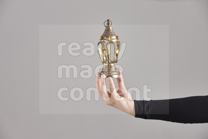 A woman in black abaya holding different ramadan lanterns in different positions
