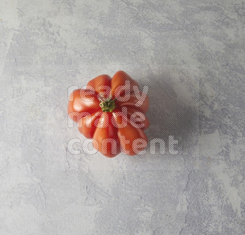 Single Topview Heirloom Tomato on a sky blue background