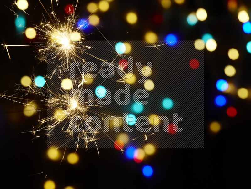 Sparkler candles with multicolored light bokeh background