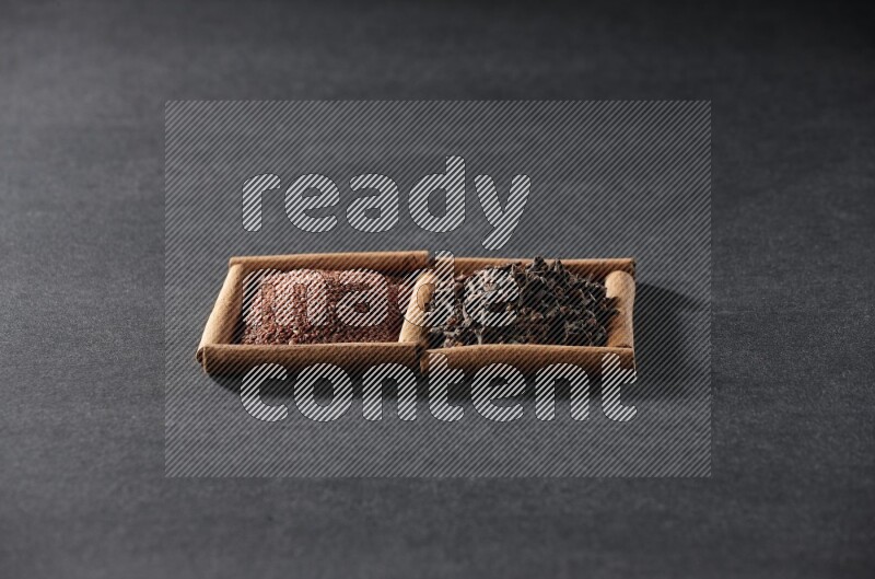 2 squares of cinnamon sticks full of garden cress and cloves on black flooring