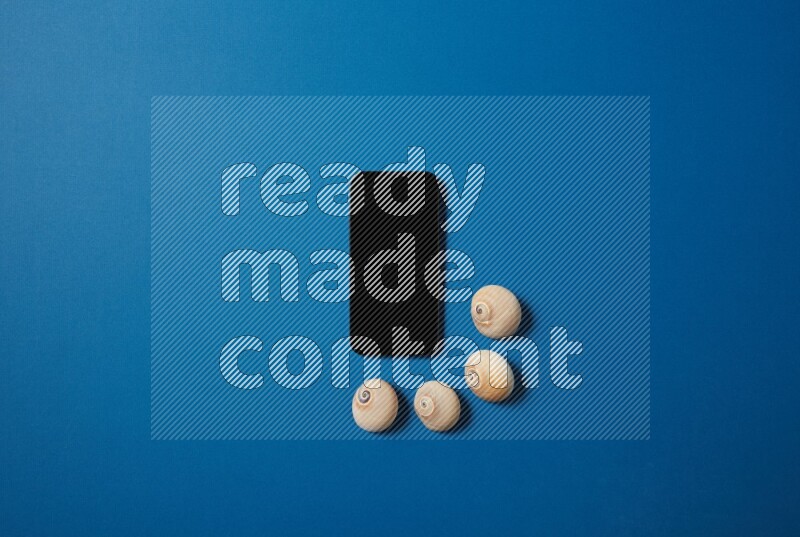 top view shot of phone with seashells on blue background