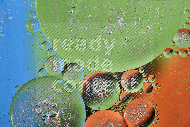 Close-ups of abstract oil bubbles on water surface in shades of orange, green and blue