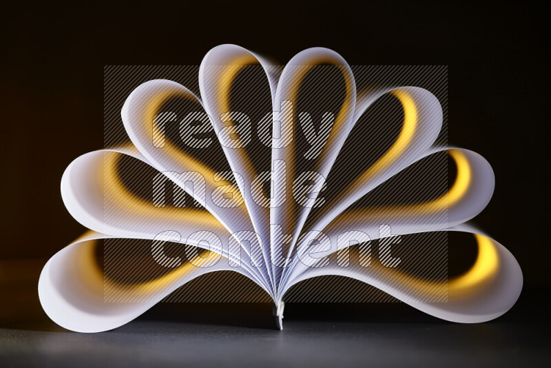 An abstract art piece displaying smooth curves in yellow and white gradients created by colored light