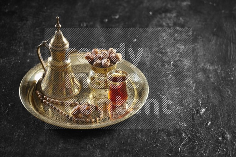 تمر مع مشروب ساخن على صينية معدنية