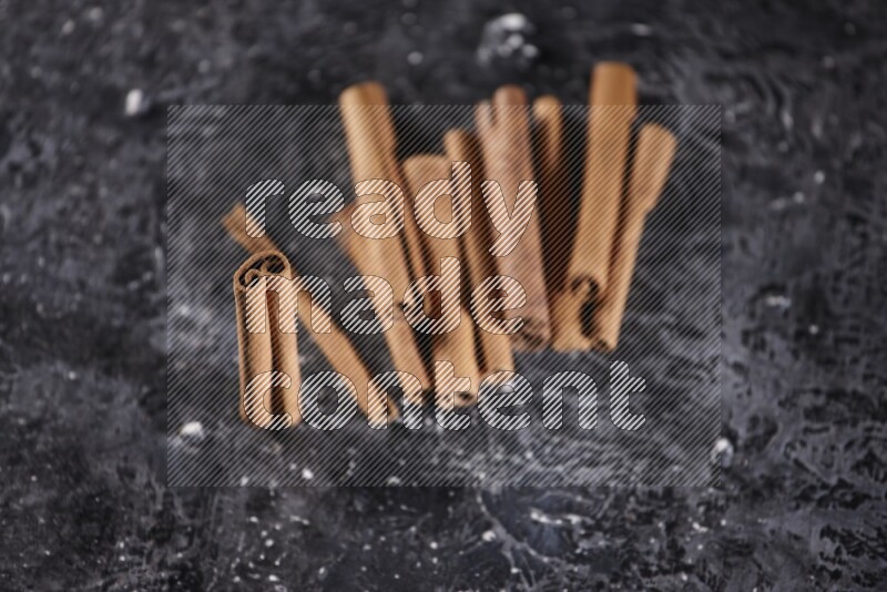 Cinnamon sticks on a textured black background