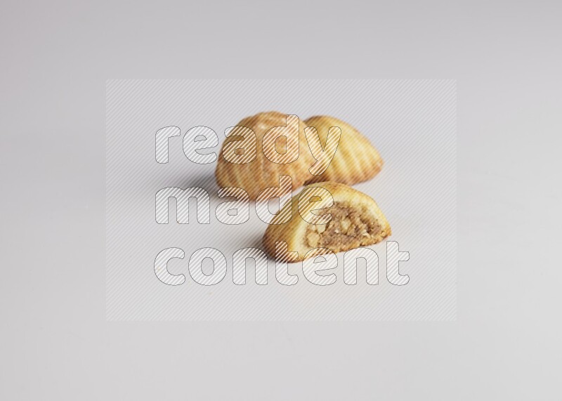 Three Pieces of Maamoul filled with walnut paste  one of them is cut direct on white background