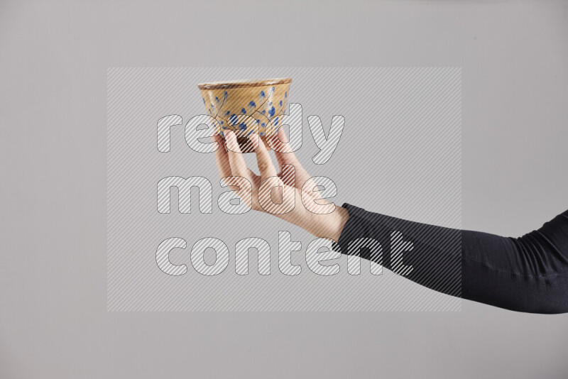 A woman in black abaya holding different pottery essentials in different positions